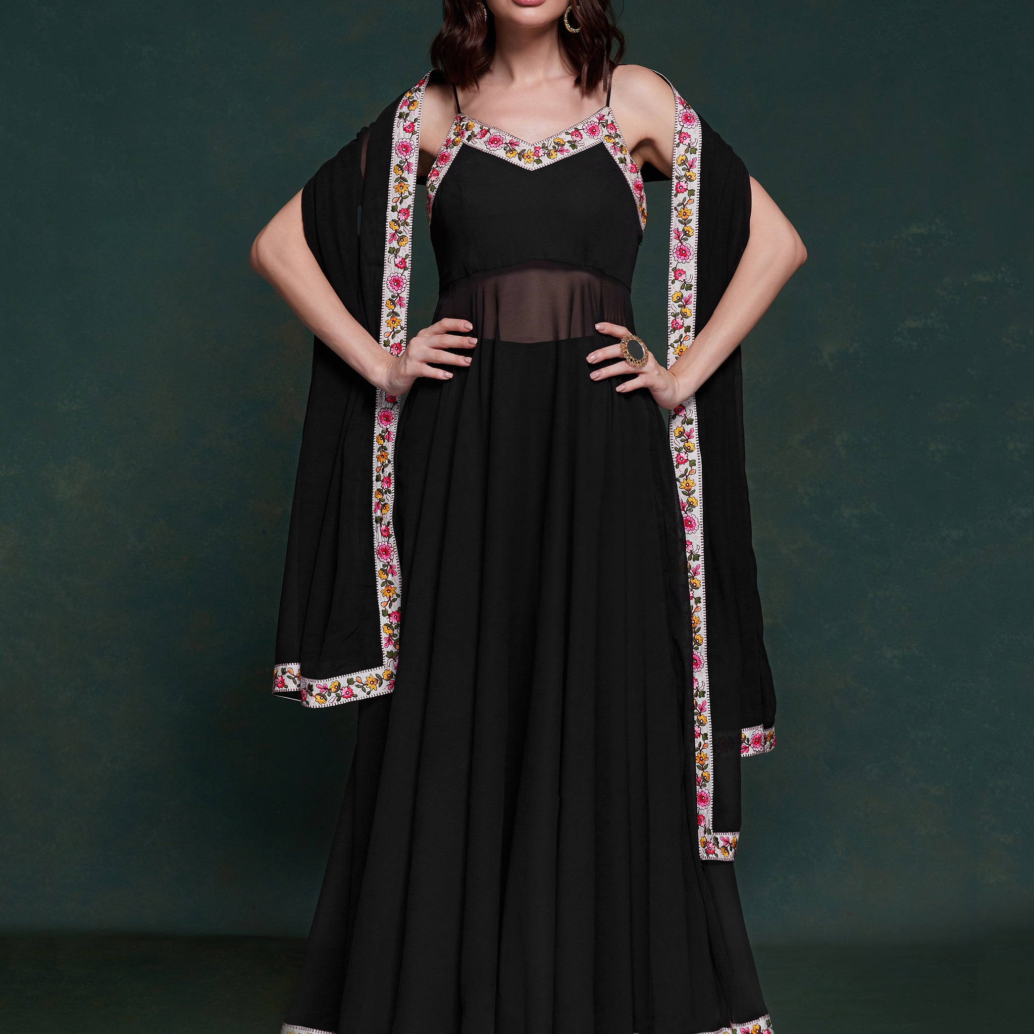 Discover elegance with this exquisite black georgette long suit, featuring intricate lacework that adds a touch of refinement.  The suit is fully stitched and available in sizes XS to XXL, offering a perfect fit and a sophisticated silhouette. Its timeless black color ensures versatility, making it a standout choice for festivals, functions, and special events. The ensemble is completed with matching black georgette pants and a dupatta, adorned with beautiful border lace work.  This coordinated design enhan