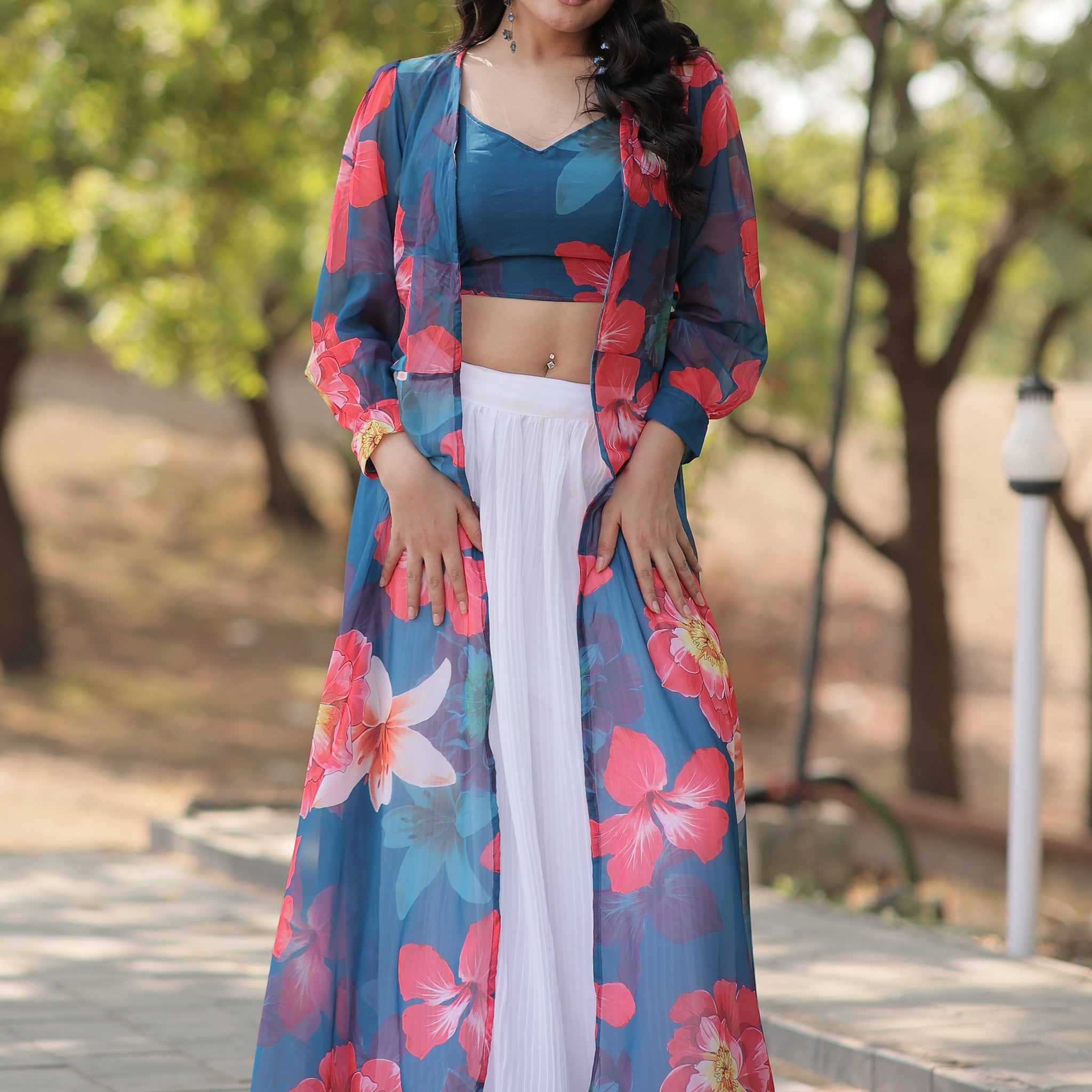 Make a graceful statement with this beautiful white georgette crush lehenga. Fully stitched and available in size L, the lehenga features a classic white fabric with a sophisticated textured finish.  The look is elevated by a sky-blue georgette crop top adorned with vibrant floral prints, adding a fresh and contemporary touch. Completing the ensemble is a sky-blue georgette jacket, also detailed with floral prints, which adds an extra layer of elegance.  Perfect for festivals, parties, or casual gatherings,