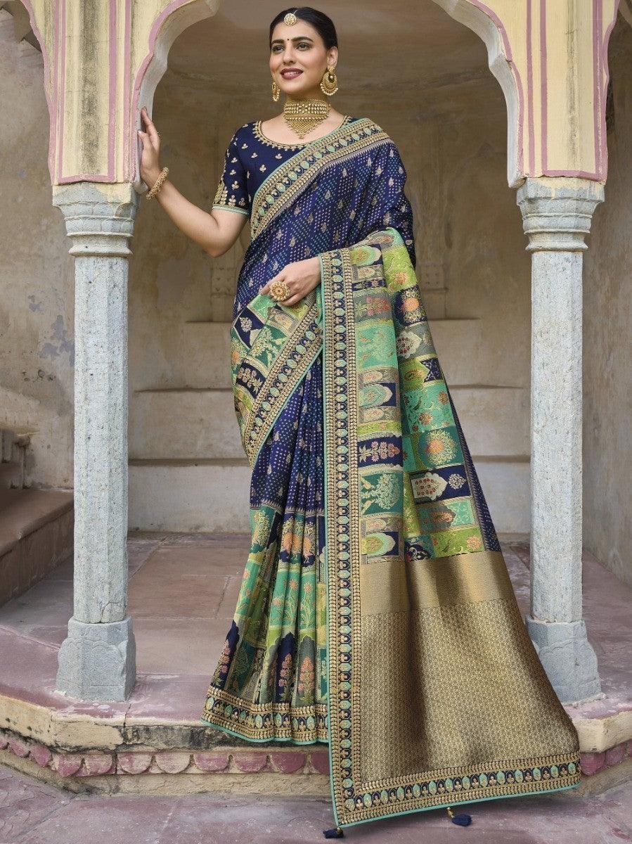 Woman in elegant blue and green printed saree with gold border, traditional Indian fashion