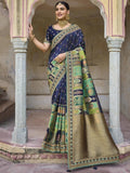 Woman in elegant blue and green printed saree with gold border, traditional Indian fashion