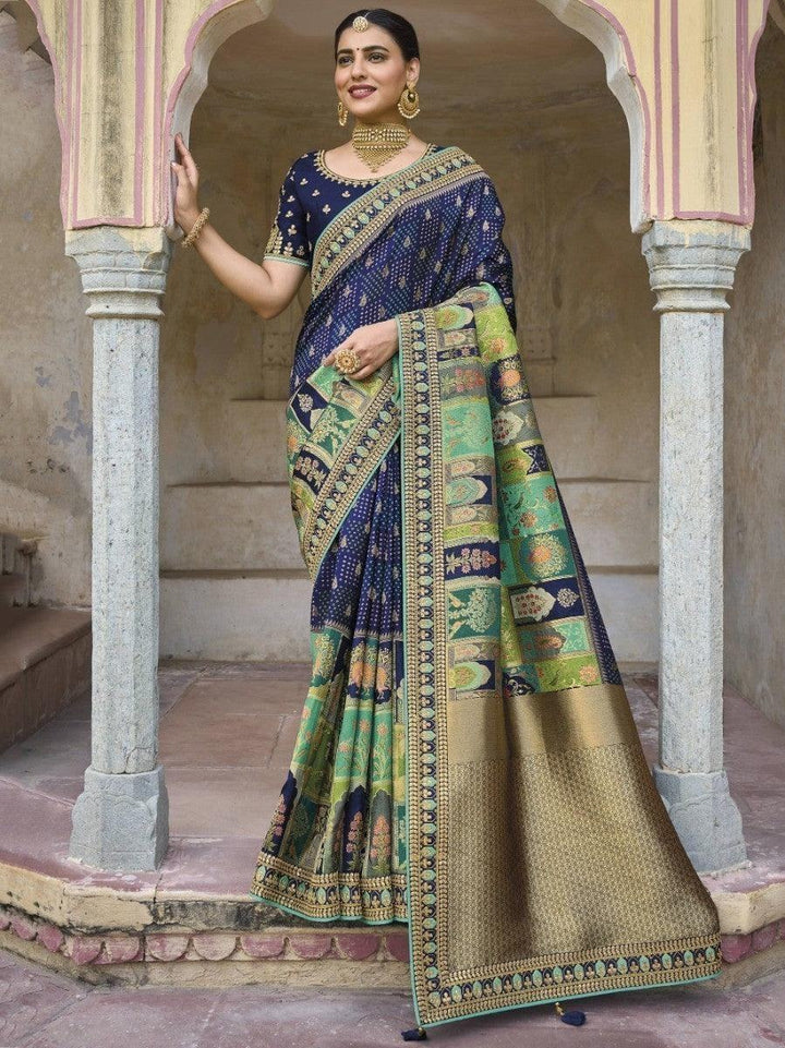 Woman in elegant blue and green printed saree with gold border, traditional Indian fashion