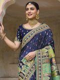 Elegant navy blue saree with gold embroidery and green border, paired with traditional jewelry for festive occasions