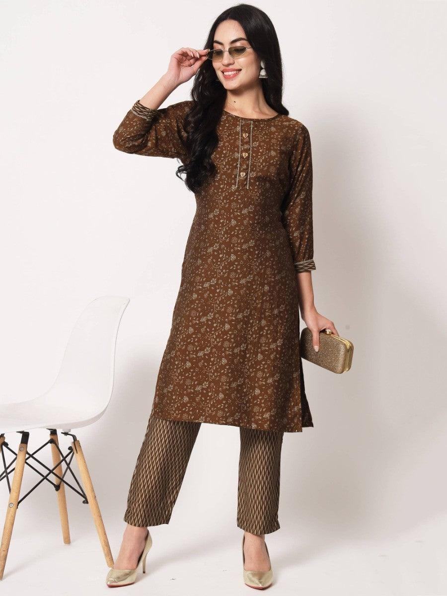 Woman in brown floral kurta with patterned pants, gold heels, and clutch, stylish women's fashion outfit