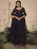 Woman in elegant navy blue embroidered anarkali dress with floral detailing, perfect for festive occasions.