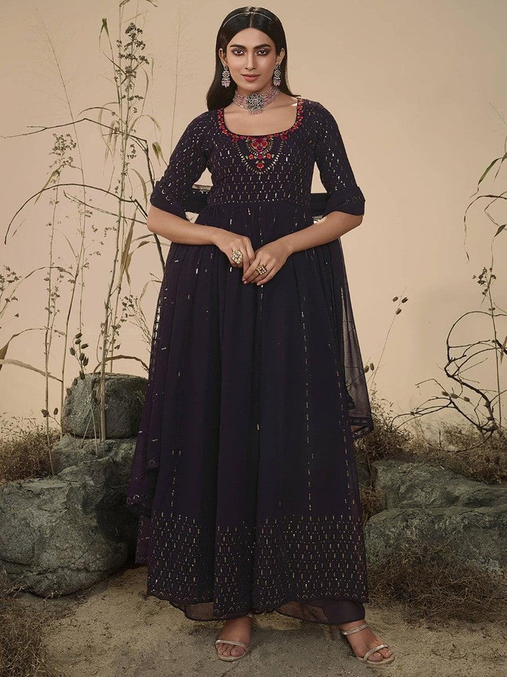 Woman in elegant navy blue embroidered anarkali dress with floral detailing, perfect for festive occasions.