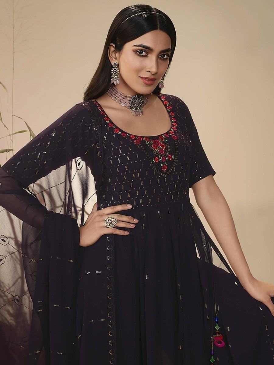 Woman in elegant navy blue embroidered anarkali dress with floral detailing, perfect for festive occasions.