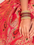 Vibrant pink saree with gold paisley print and traditional bangles, perfect for festive occasions.