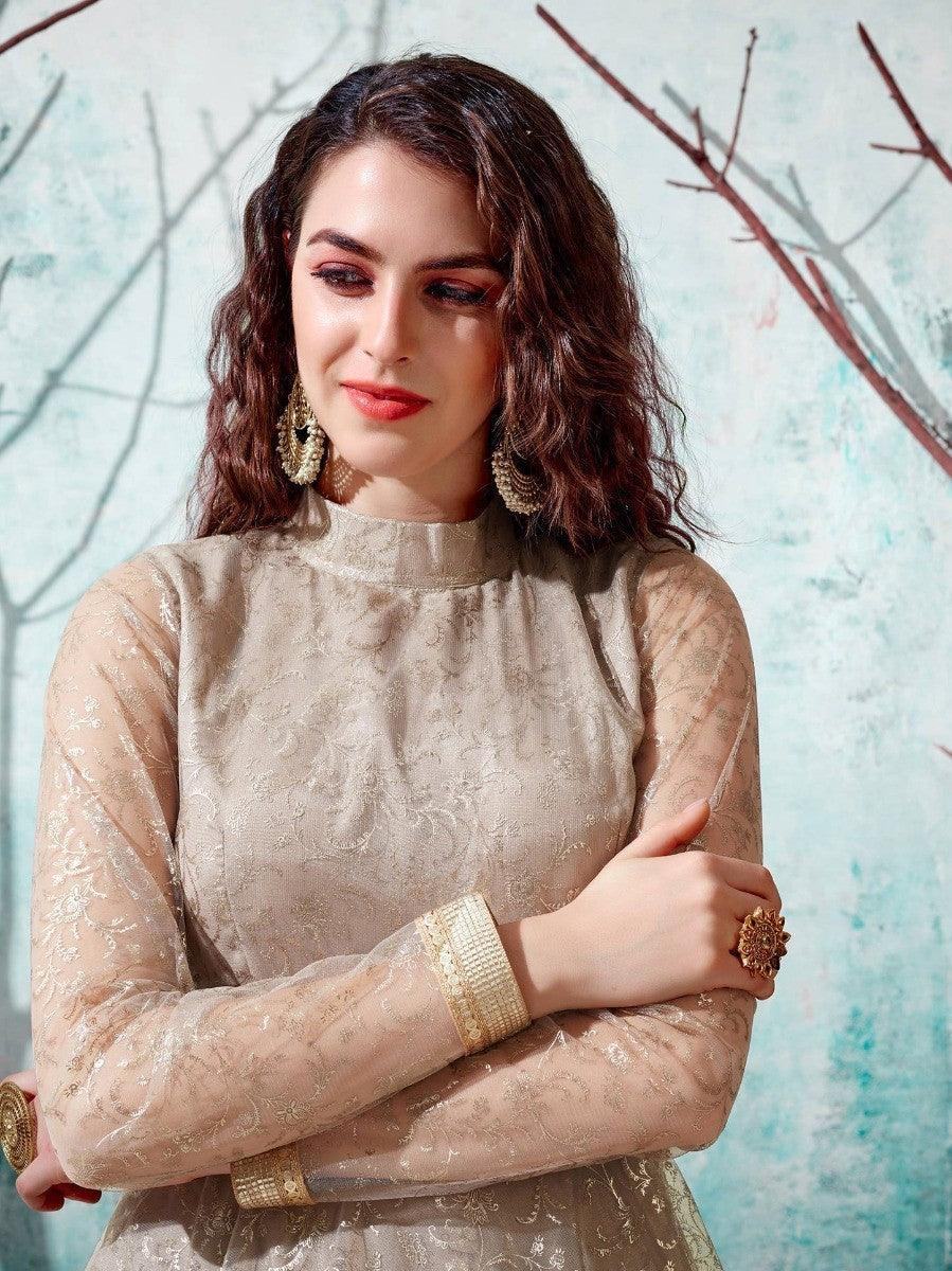 Elegant woman in beige embroidered long-sleeve top with gold jewelry, perfect for festive occasions.