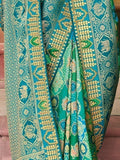 Teal and green embroidered saree with gold floral and elephant motifs, traditional Indian fashion