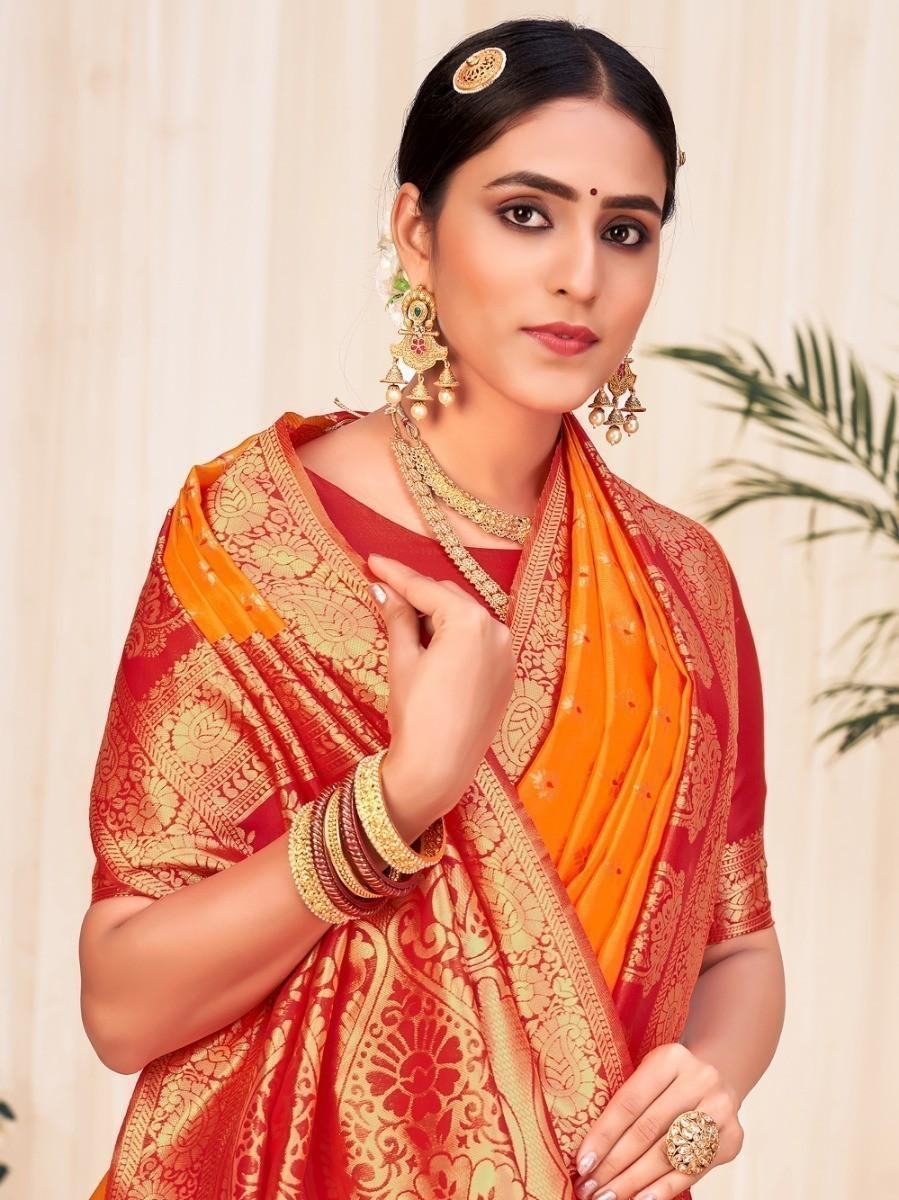 Woman in red and orange traditional saree with gold embroidery and jewelry, elegant ethnic wear