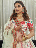 Woman in floral embroidered Indian suit with red gold detailing, pearl jewelry, and sheer dupatta