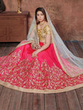 Woman in pink and gold embroidered lehenga with sheer dupatta, traditional Indian bridal wear