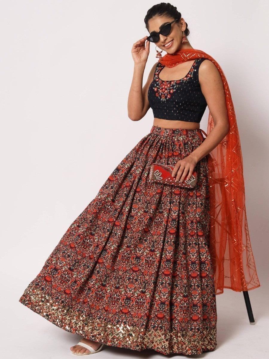 Woman in floral lehenga with black embroidered crop top and orange dupatta, stylish ethnic wear