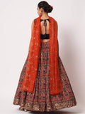 Woman in floral lehenga with orange dupatta, back view, festive Indian attire