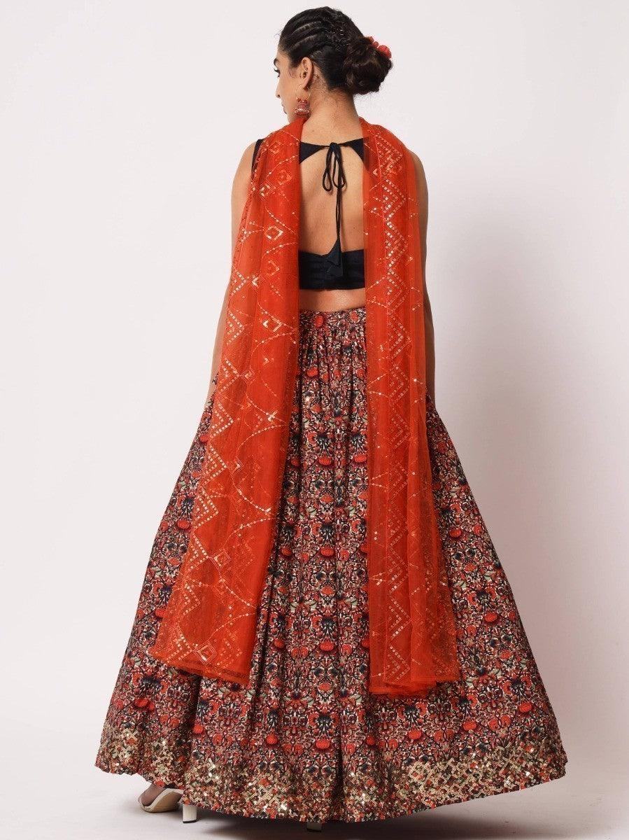 Woman in floral lehenga with orange dupatta, back view, festive Indian attire