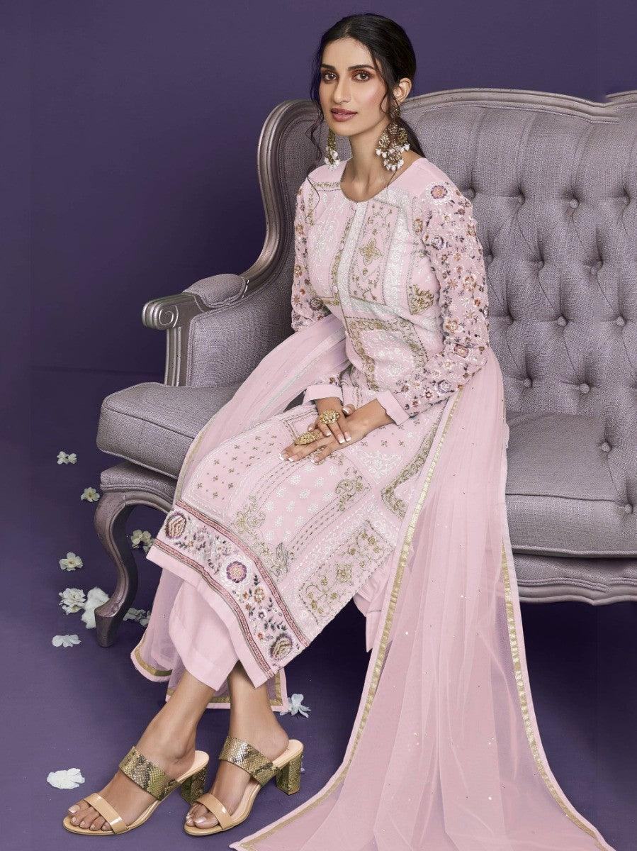 Elegant pink embroidered women's outfit with gold detailing, styled with heels and statement earrings